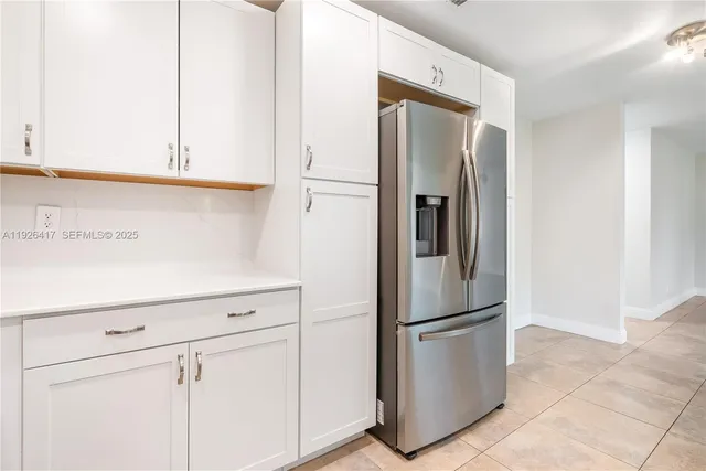 a metallic refrigerator freezer sitting in a kitchen