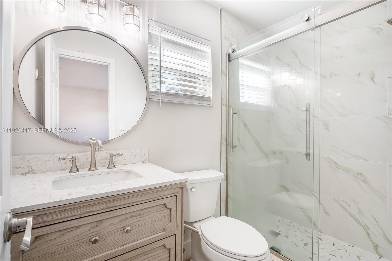 8172 Northwest 67th Avenue Tamarac, FL 33321 - Photo 15 of 44 a bathroom with a sink a mirror a toilet and shower