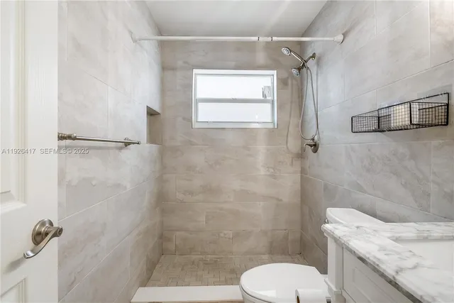 a bathroom with a toilet a sink and shower