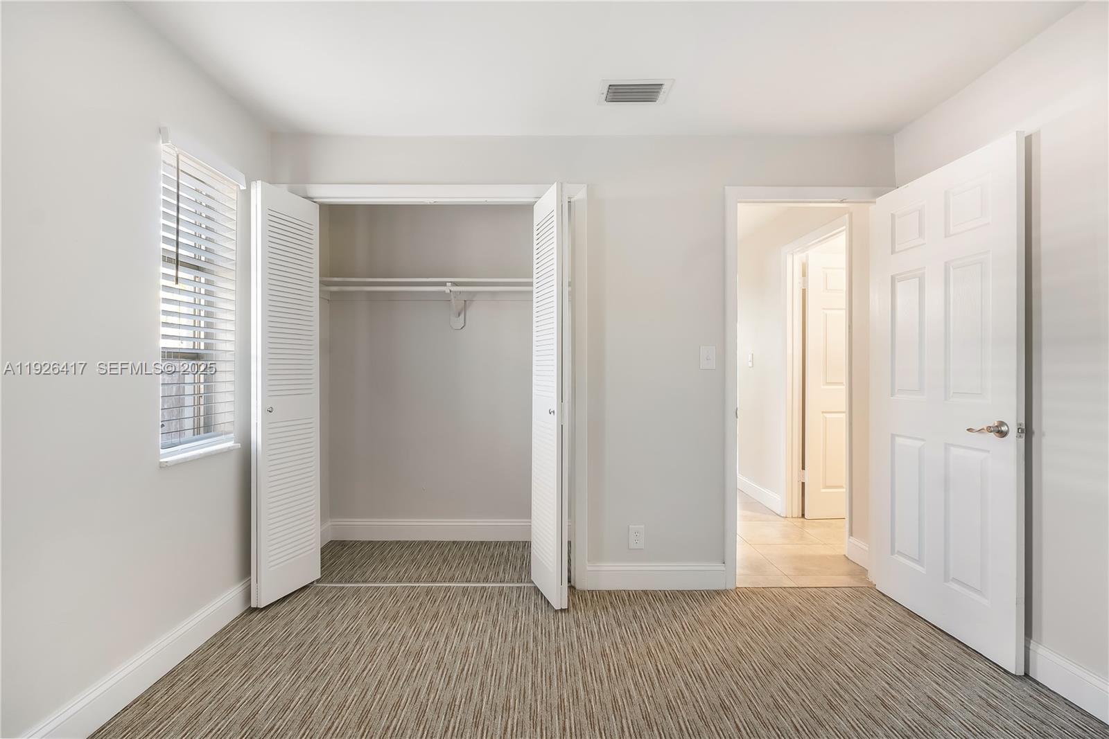8172 Northwest 67th Avenue Tamarac, FL 33321 - Photo 21 of 44 a view of an empty room with wooden floor and a window