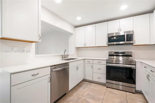 a kitchen with cabinets stainless steel appliances and sink