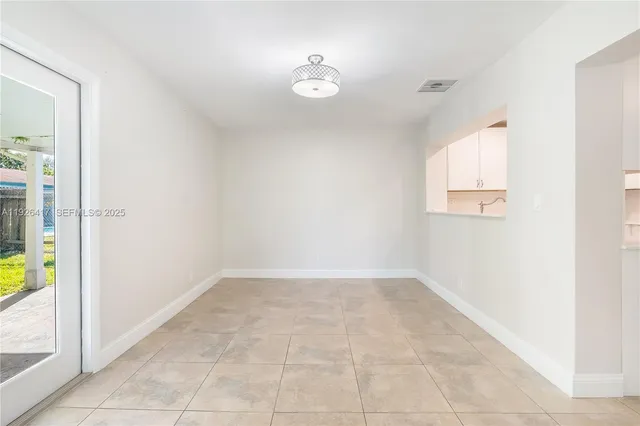 an empty room with a bathroom and a window