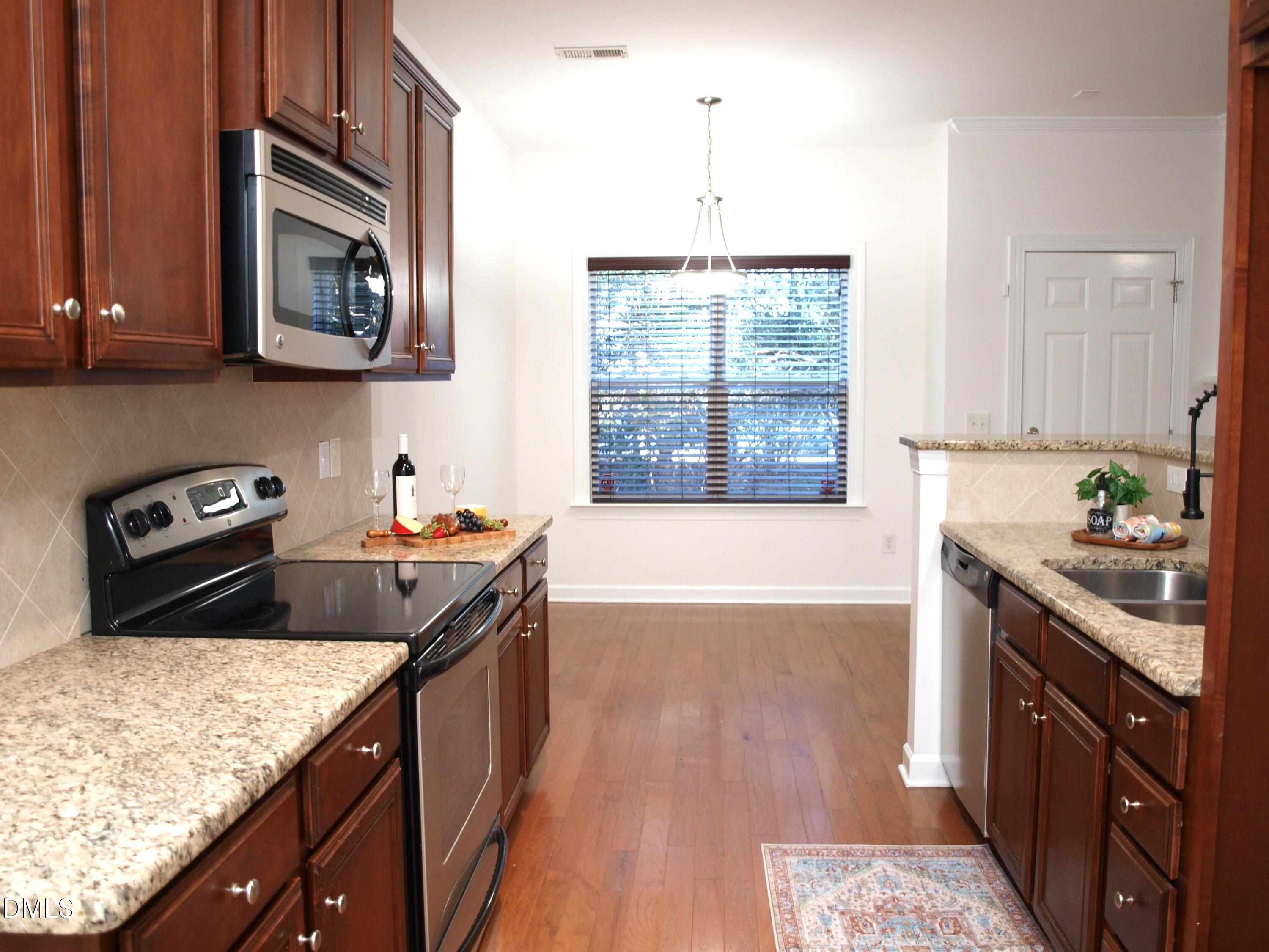 4815 Landover Charge Lane Raleigh, NC 27616 - Photo 4 of 18 a kitchen with a sink stove and microwave