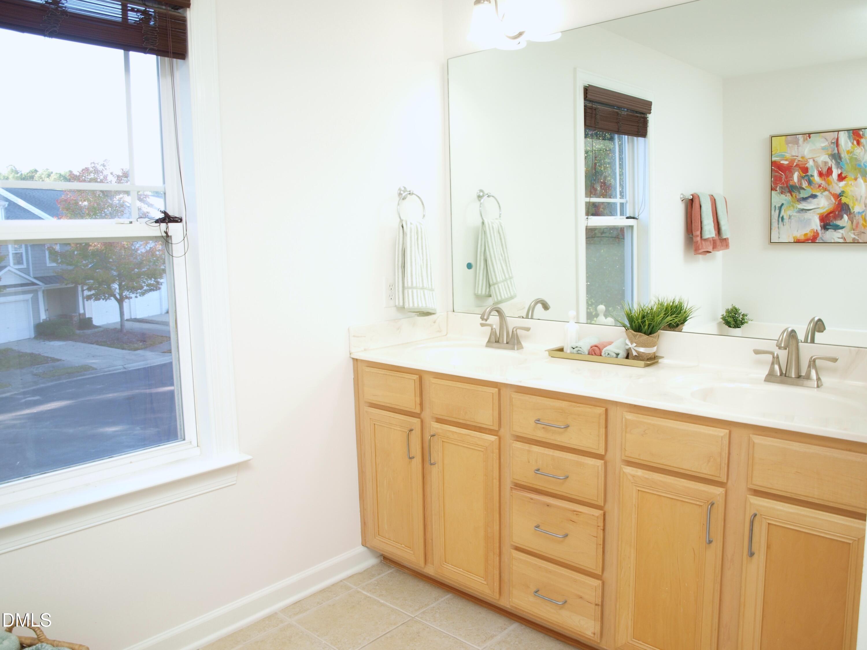 4815 Landover Charge Lane Raleigh, NC 27616 - Photo 9 of 18 a bathroom with a double vanity sink and a mirror