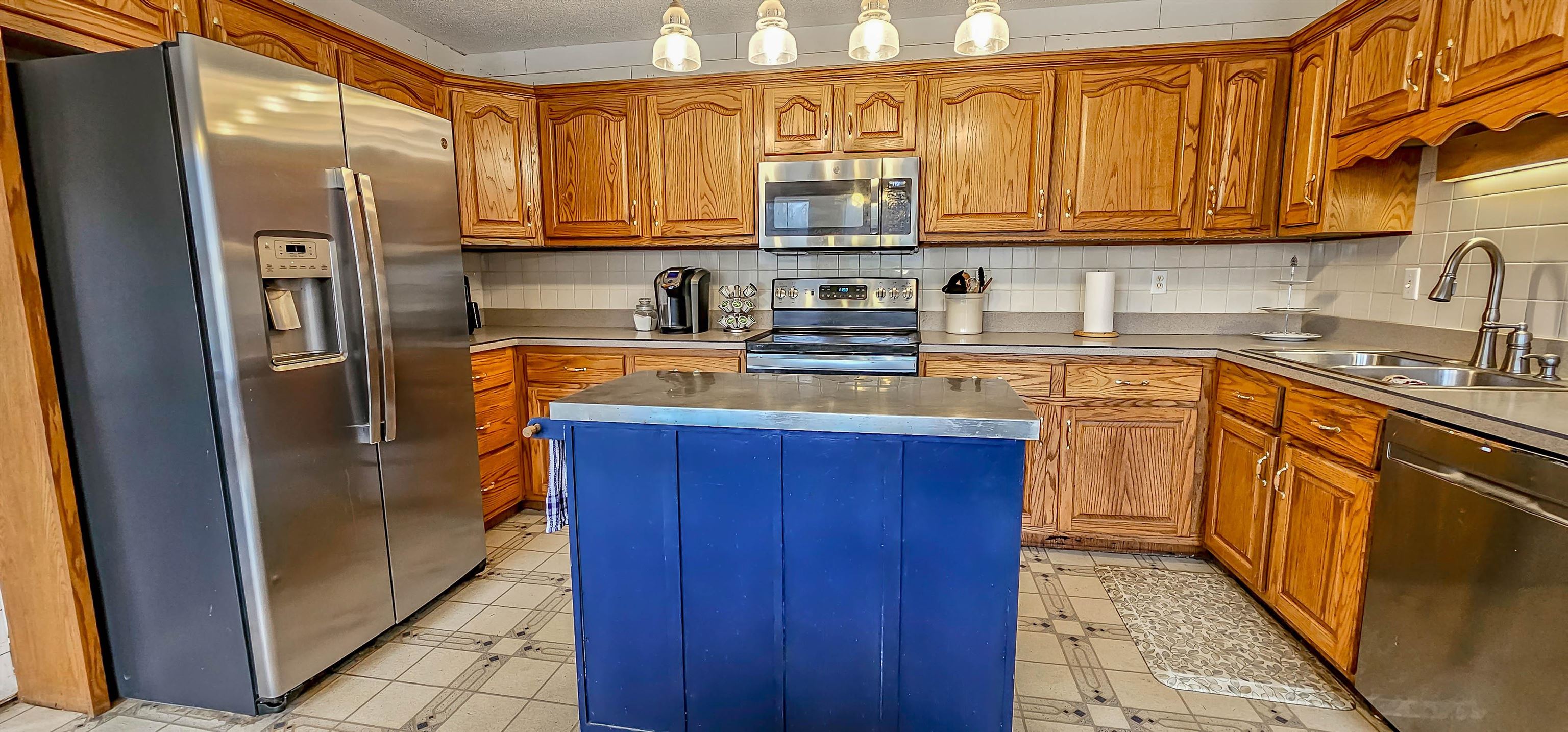 380 Bethel Road Atoka, TN 38004 - Photo 12 of 36 Kitchen featuring sink, stainless steel appliances, a center island, a textured ceiling, and decorative backsplash