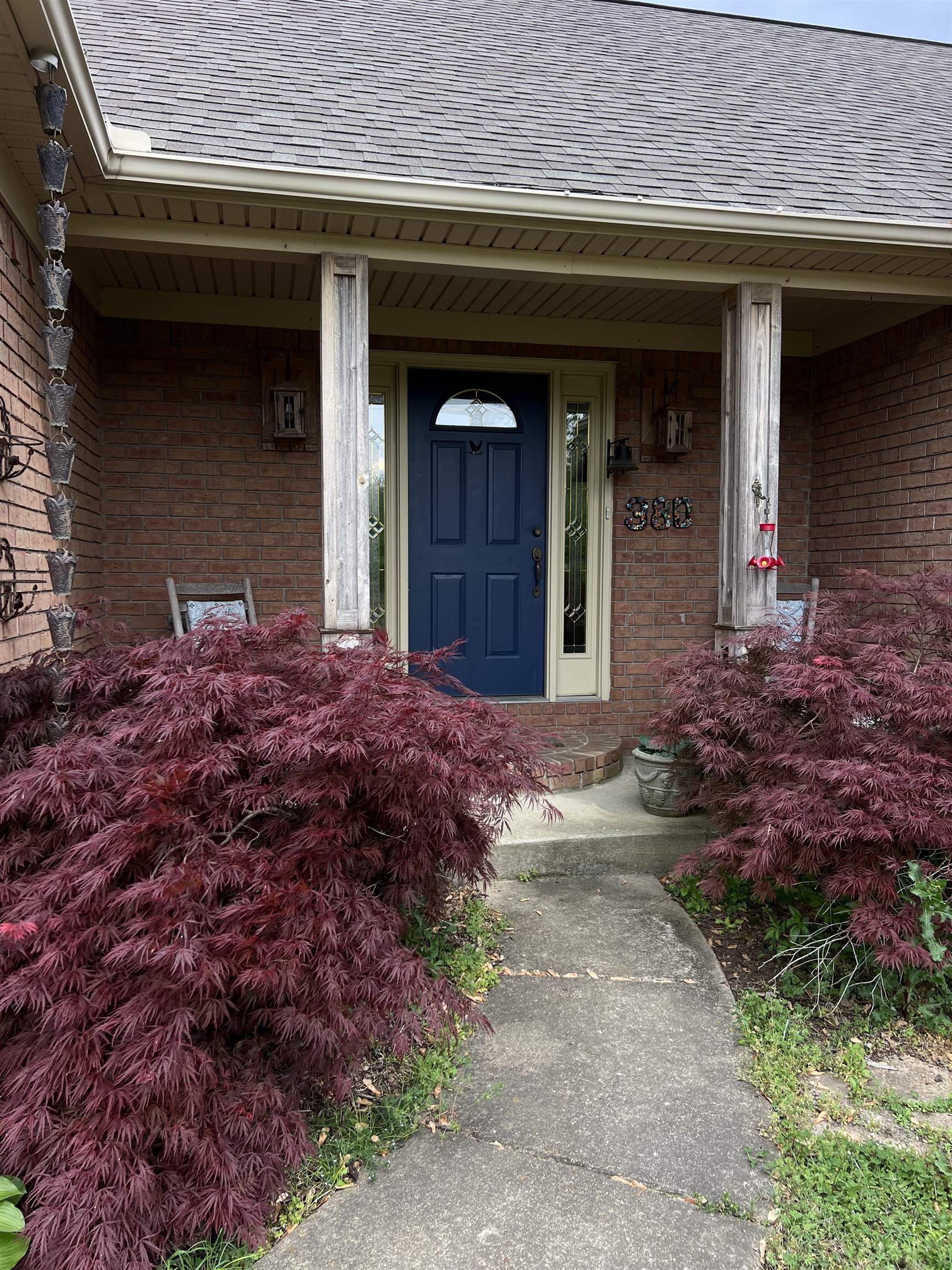 380 Bethel Road Atoka, TN 38004 - Photo 2 of 36 Doorway to property featuring a porch, a shingled roof, and brick siding