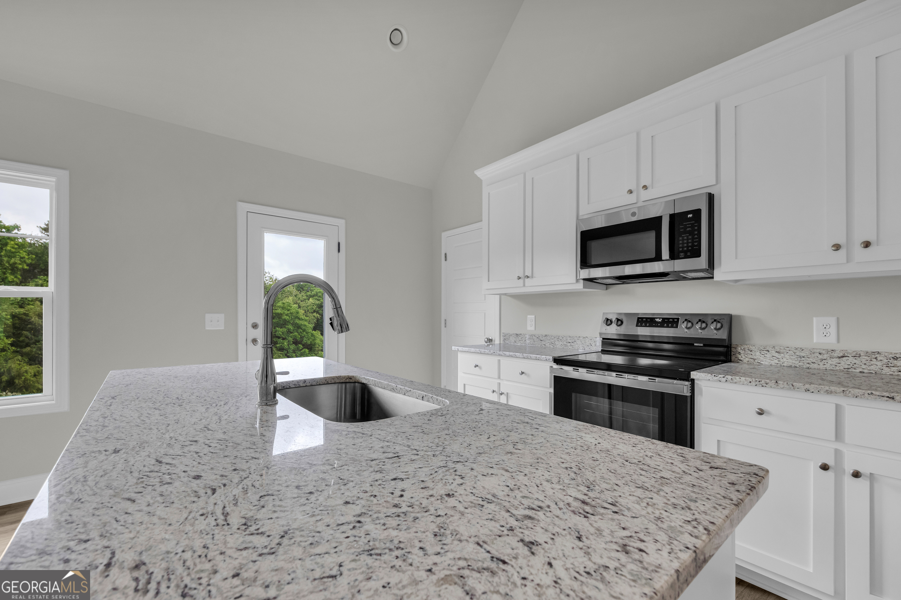 110 Sewell Road Lavonia, GA 30553 - Photo 41 of 73 a kitchen with stainless steel appliances granite countertop a stove a sink and a white cabinets
