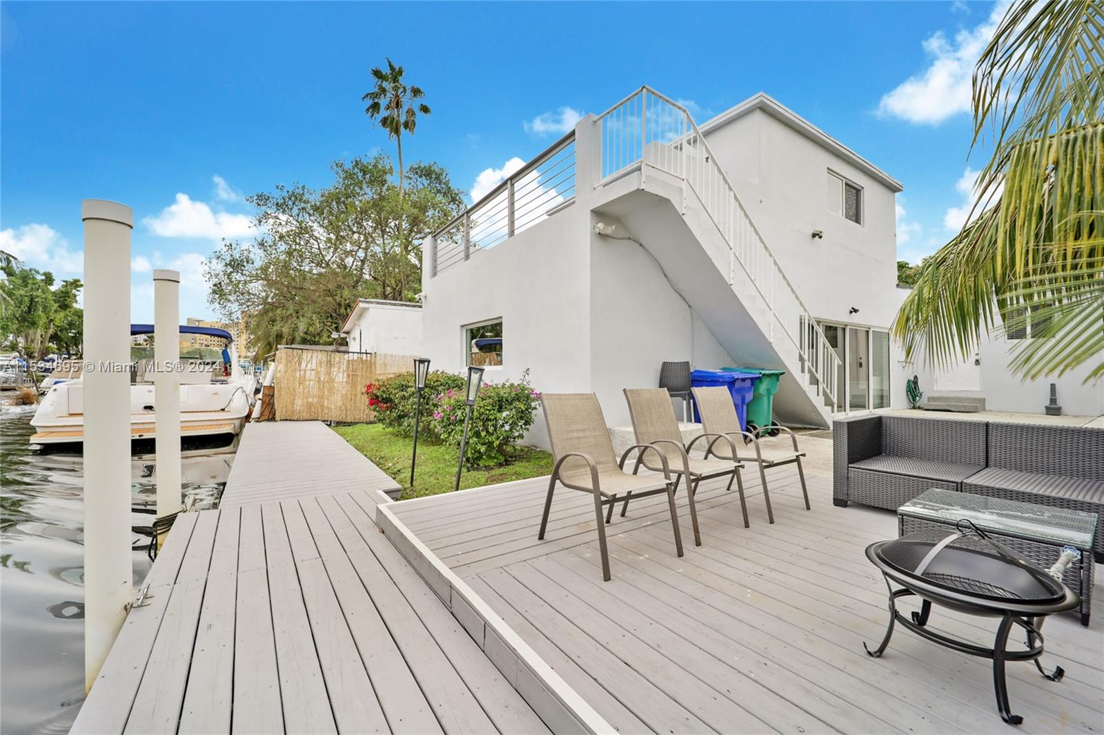 a view of a patio with couches table and chairs with wooden floor and fence