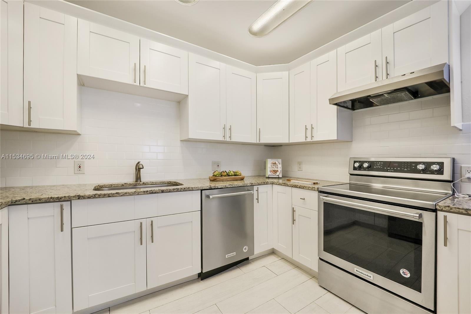 805 Northwest 7th Street Miami, FL 33136 - Photo 12 of 29 a kitchen with granite countertop white cabinets and stainless steel appliances