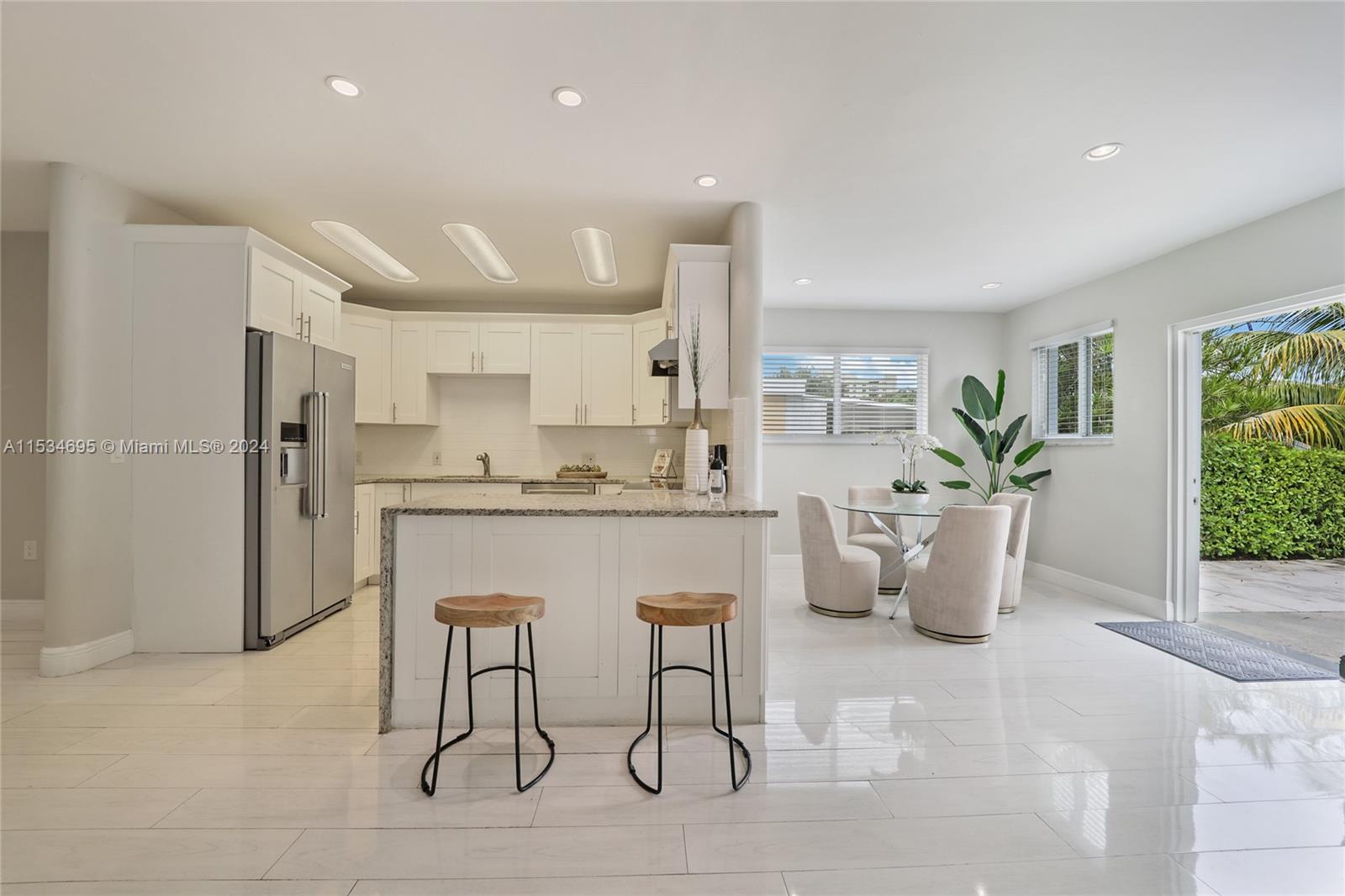 805 Northwest 7th Street Miami, FL 33136 - Photo 13 of 29 a kitchen with stainless steel appliances kitchen island granite countertop a refrigerator a sink a stove and white cabinets
