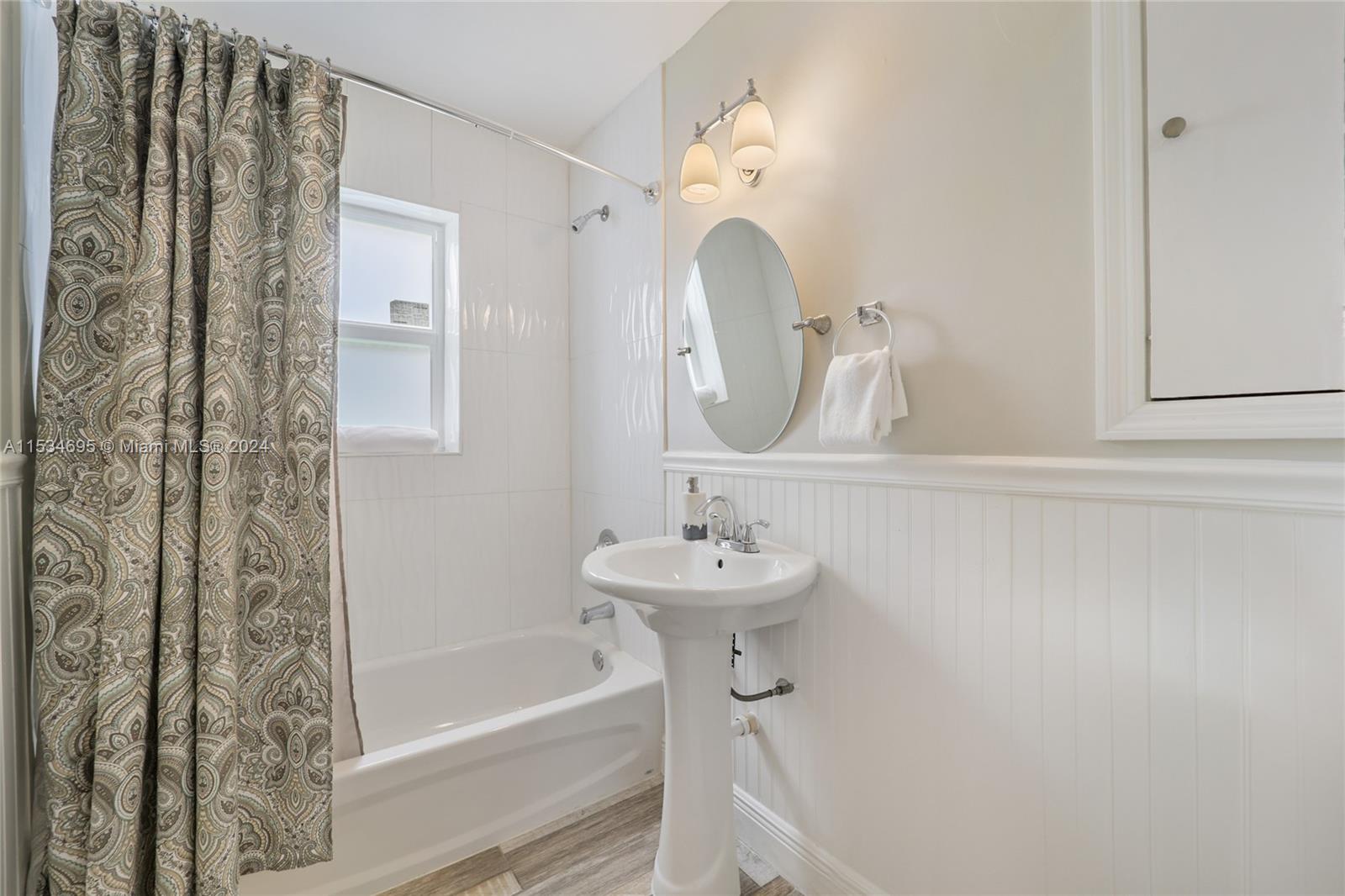 805 Northwest 7th Street Miami, FL 33136 - Photo 26 of 29 a bathroom with a sink a mirror and a bathtub