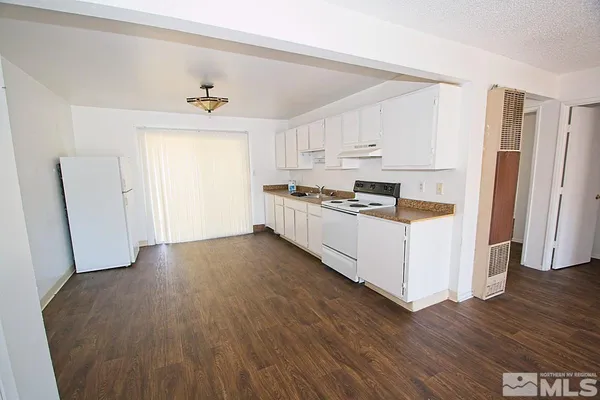 a kitchen with stainless steel appliances a refrigerator and wooden floor