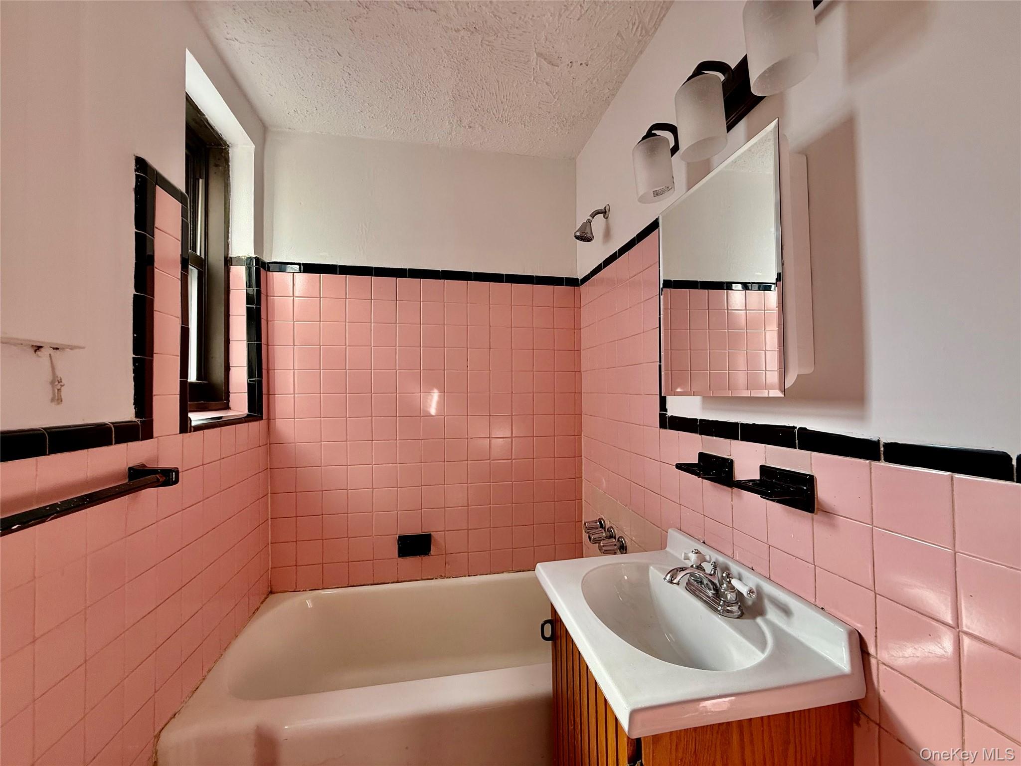 112-24 Northern Boulevard, Unit 3G Queens, NY 11368 - Photo 19 of 33 Bathroom featuring tile walls, a textured ceiling, vanity, shower / bath combination, and backsplash
