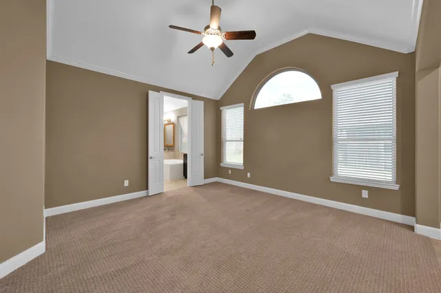 a view of an empty room with a chandelier fan