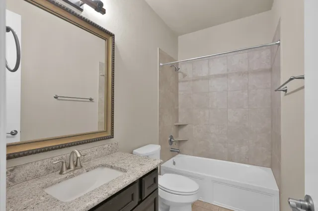 an empty room with a chandelier fan and windows