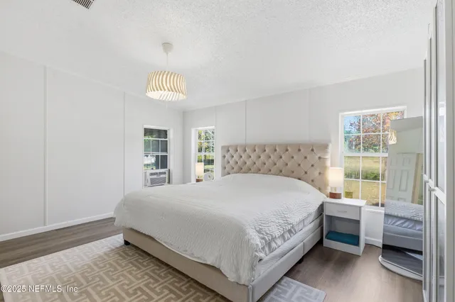 a large bedroom with a bed and wooden floor