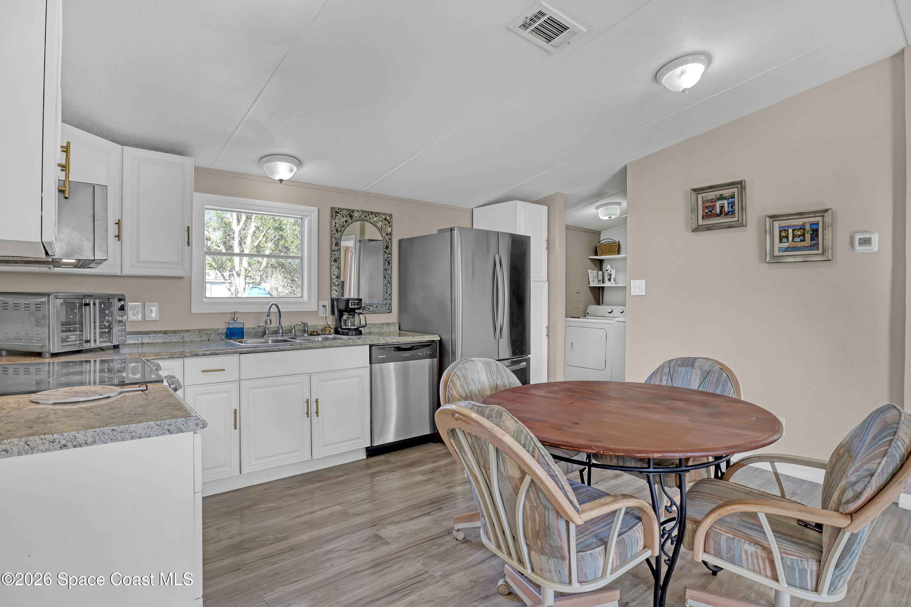 354 Akorn Street Cocoa, FL 32927 - Photo 2 of 29 a kitchen with stainless steel appliances granite countertop a kitchen island hardwood floor and a sink