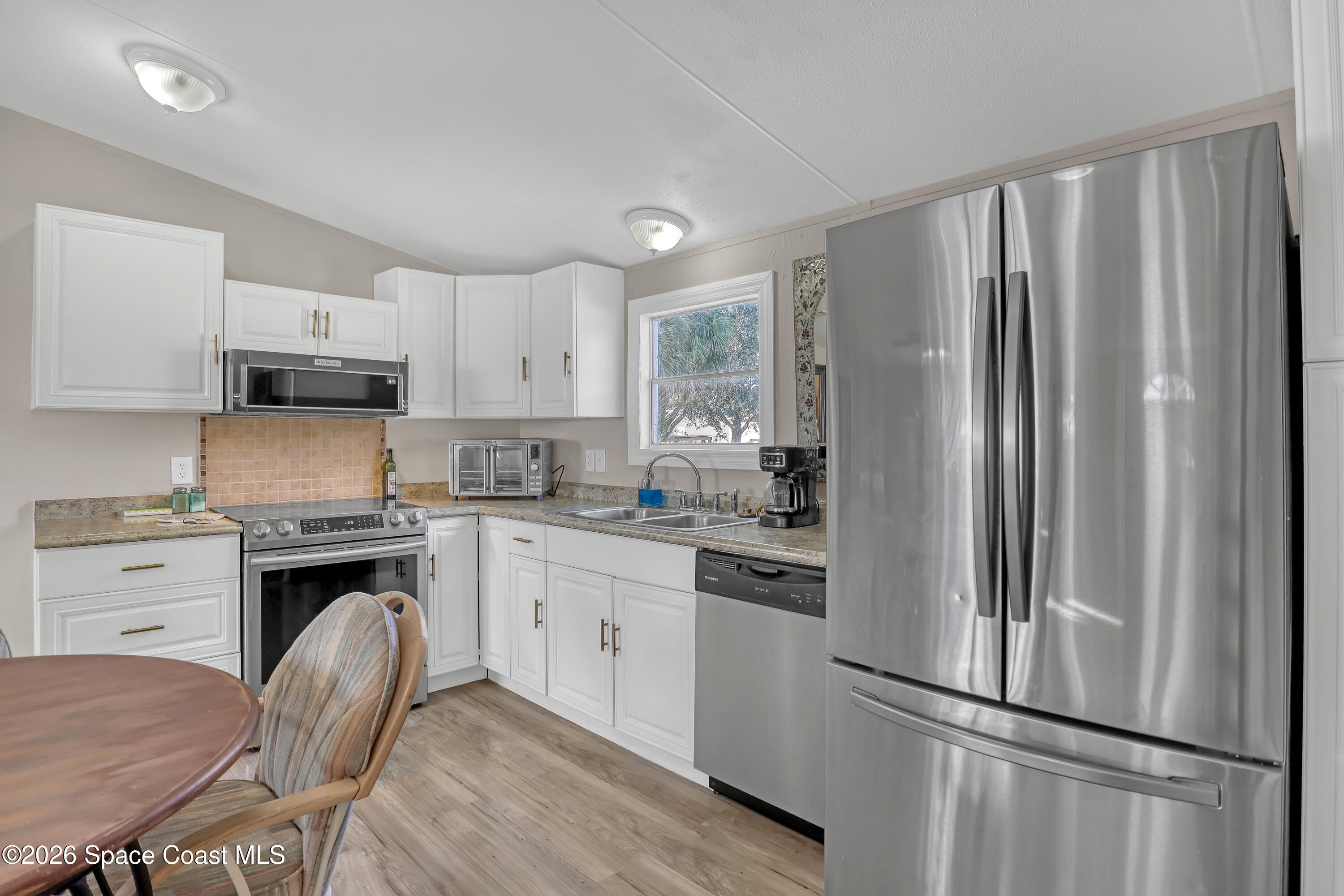 354 Akorn Street Cocoa, FL 32927 - Photo 3 of 29 a kitchen with stainless steel appliances granite countertop a refrigerator stove microwave and sink