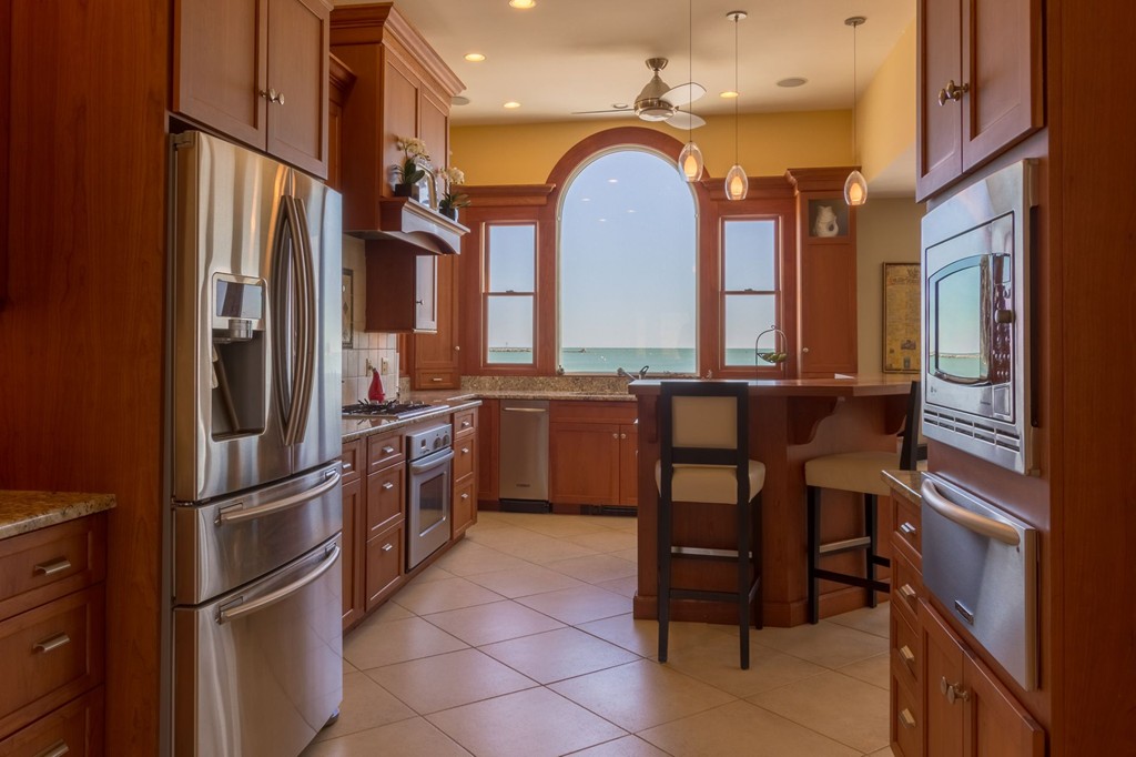 126-128 Jericho Road Scituate, MA 02066 - Photo 5 of 29 a kitchen with a refrigerator a sink and chairs