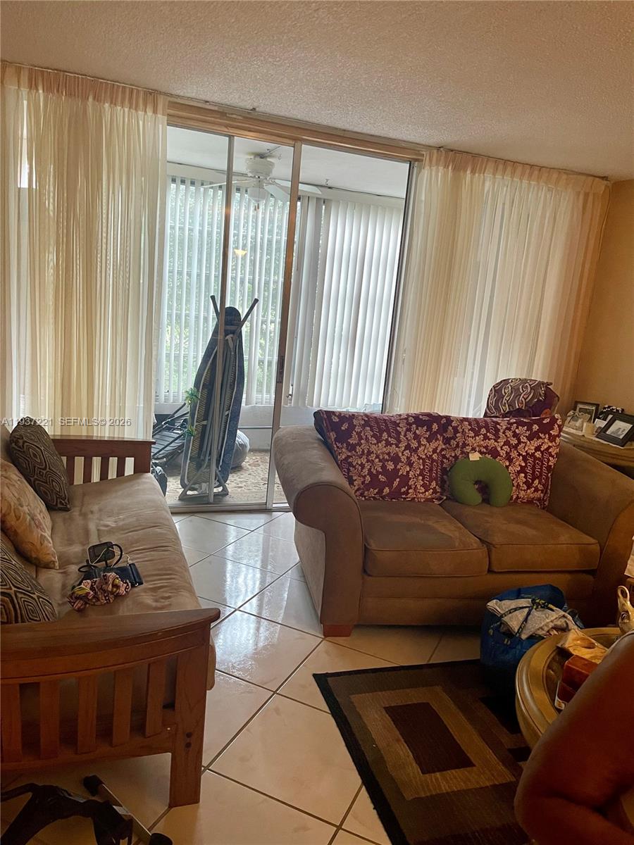 8351 Sands Point Boulevard, Unit A208 Tamarac, FL 33321 - Photo 15 of 15 a living room with furniture and a window