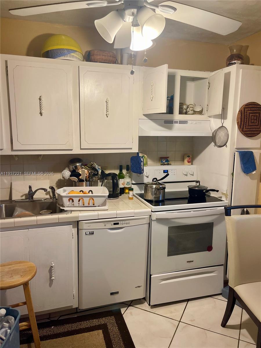 8351 Sands Point Boulevard, Unit A208 Tamarac, FL 33321 - Photo 4 of 15 a kitchen with a stove a sink and cabinets