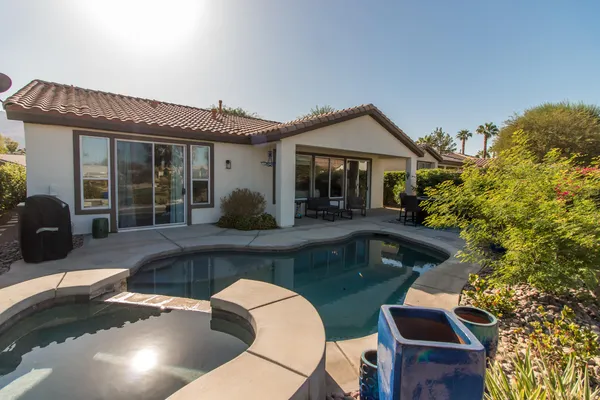 a view of a house with swimming pool and sitting area
