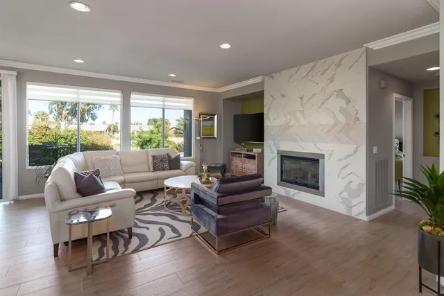 a living room with furniture a large window and a fireplace
