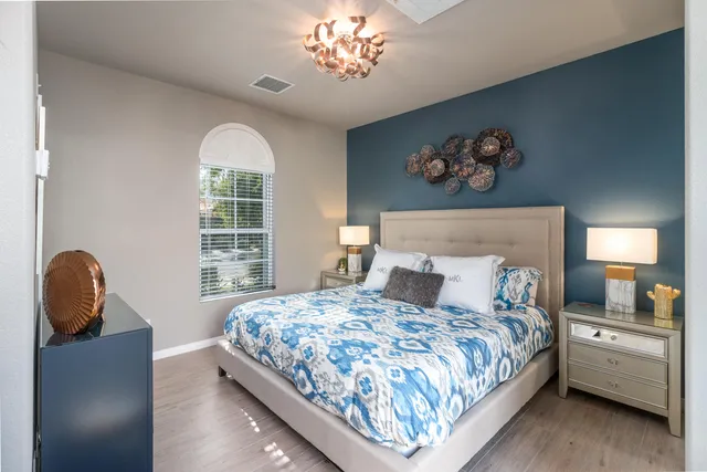 a bedroom with a bed and a painting on the wall