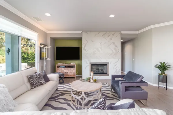 a living room with furniture a flat screen tv and a fireplace