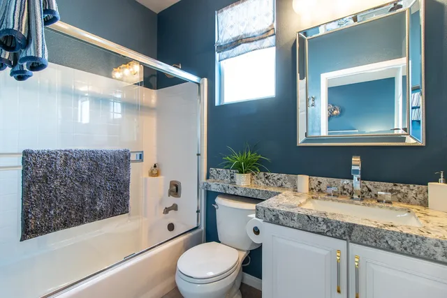 a bathroom with a granite countertop sink toilet and shower