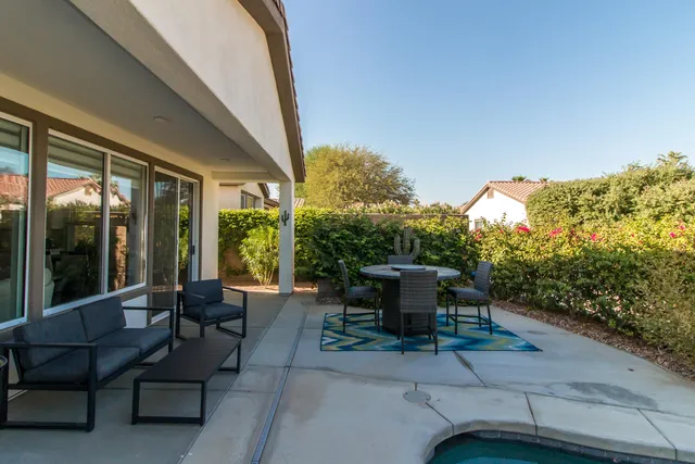 a view of a patio with couches table and chairs and potted plants