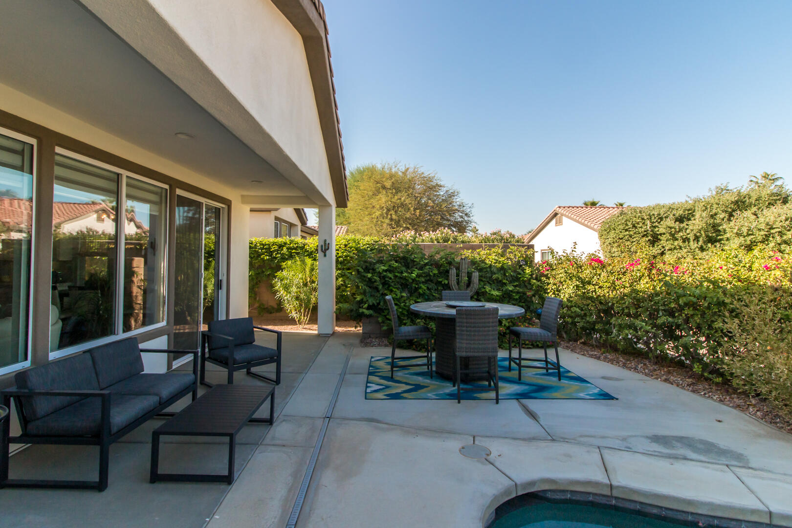 60290 Sweetshade Lane La Quinta, CA 92253 - Photo 9 of 28 a view of a patio with couches table and chairs and potted plants