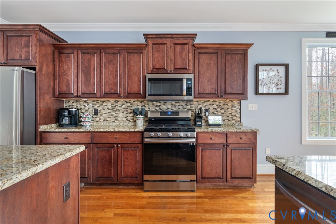8825 First Branch Lane Chesterfield, VA 23838 - Photo 12 of 63 a kitchen with stainless steel appliances granite countertop a stove a sink dishwasher and a microwave oven with cabinets