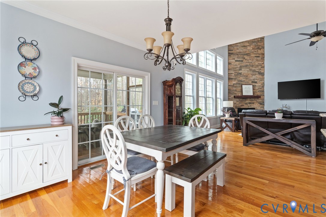 8825 First Branch Lane Chesterfield, VA 23838 - Photo 17 of 63 a view of a dining room with furniture a chandelier and wooden floor