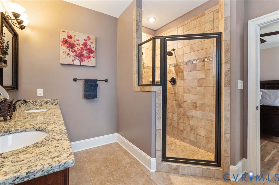 8825 First Branch Lane Chesterfield, VA 23838 - Photo 26 of 63 a bathroom with a granite countertop sink a mirror and shower