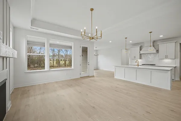 a kitchen with stainless steel appliances granite countertop a sink a oven a refrigerator and white cabinets