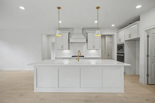 a kitchen with stainless steel appliances granite countertop a sink a stove and a refrigerator