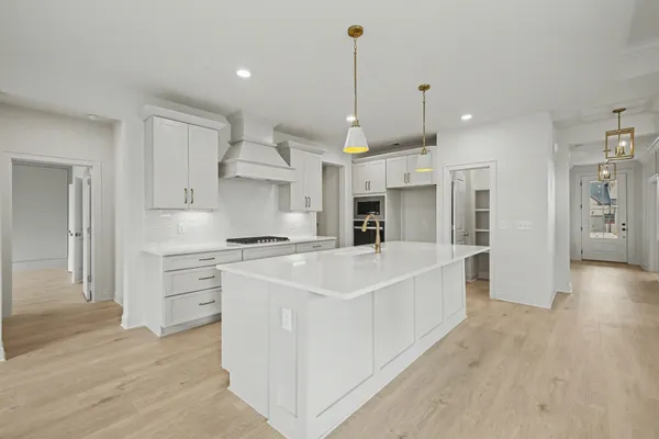 a kitchen with stainless steel appliances kitchen island granite countertop a stove and a wooden floors