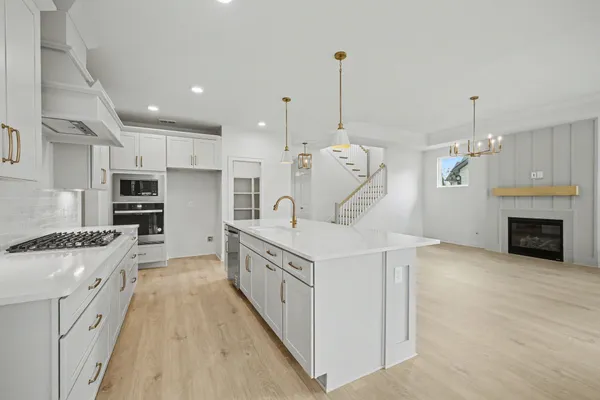a view of an empty room with window and hardwood floor
