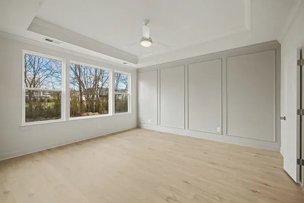 a view of an empty room with a window and a kitchen