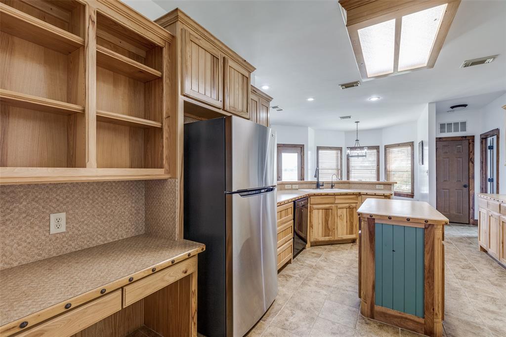 11744 Foutch Road Pilot Point, TX 76258 - Photo 13 of 35 a kitchen with a refrigerator sink and cabinets