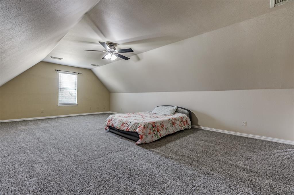 11744 Foutch Road Pilot Point, TX 76258 - Photo 23 of 35 a spacious bedroom with a bed and a ceiling fan