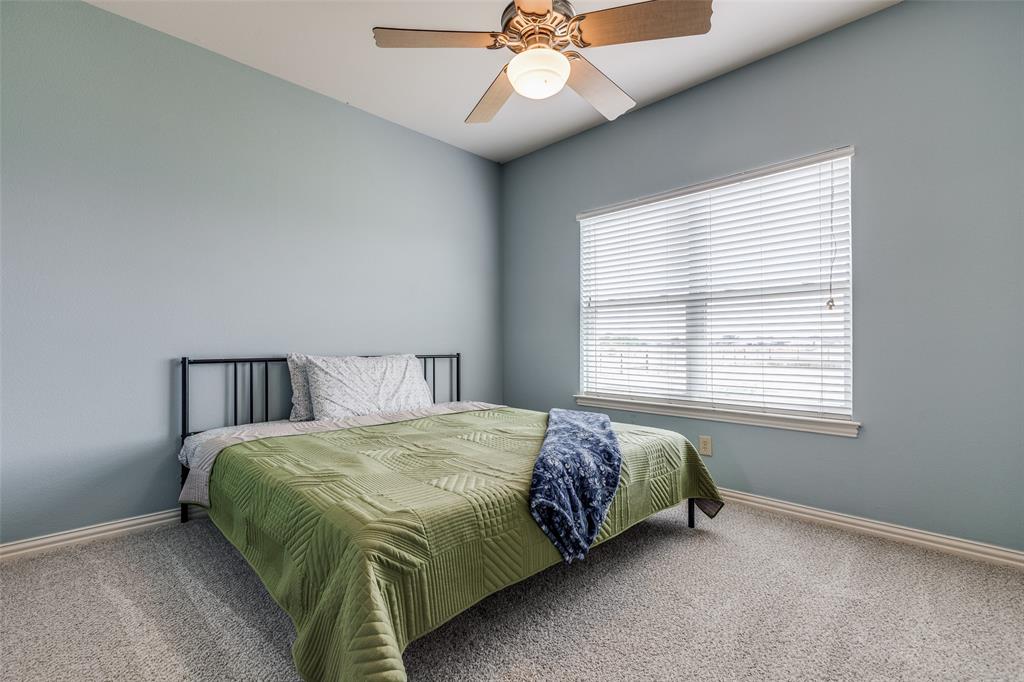 11744 Foutch Road Pilot Point, TX 76258 - Photo 26 of 35 a bedroom with a bed and a chandelier