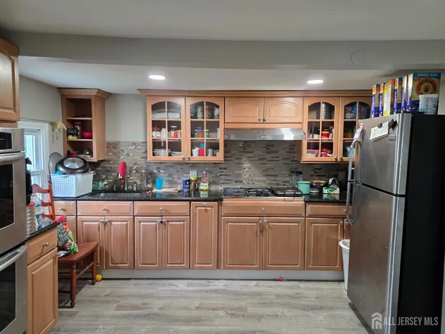 a kitchen with stainless steel appliances granite countertop a refrigerator and a sink