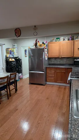 a kitchen with stainless steel appliances wooden floor and chairs