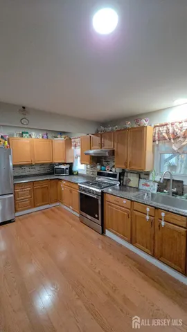 a large kitchen with granite countertop a large counter top stainless steel appliances and cabinets