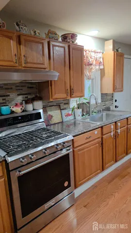 a kitchen with granite countertop a stove sink and cabinets