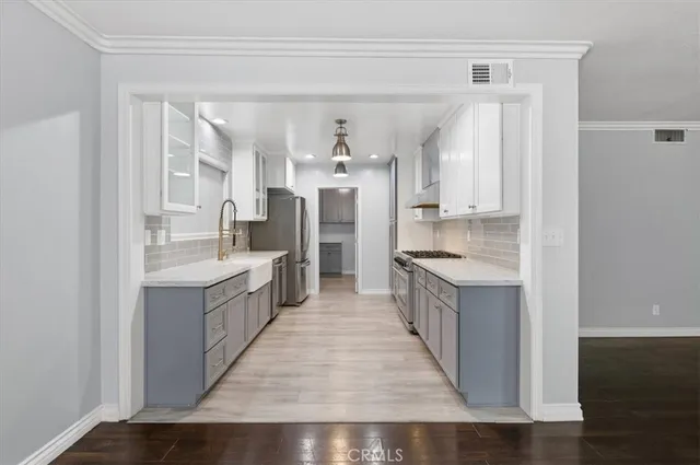 a kitchen with white cabinets and appliances