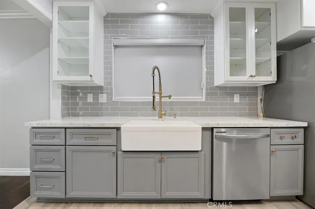 a kitchen with kitchen island a counter top space a sink stainless steel appliances and cabinets