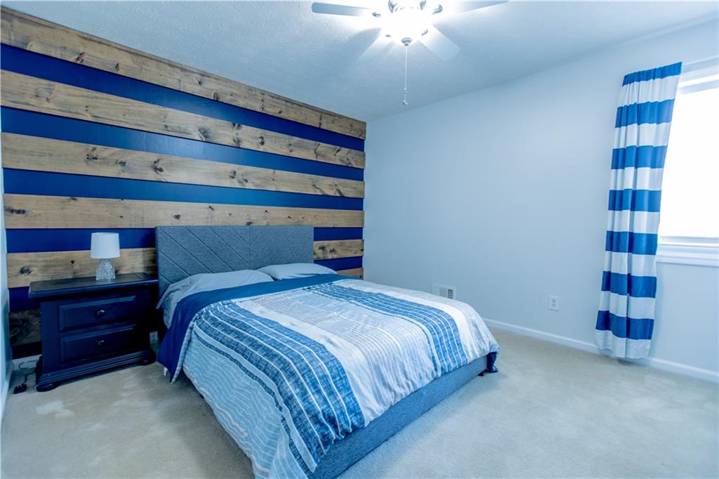 4735 North Springs Road Northwest Kennesaw, GA 30144 - Photo 20 of 34 a bedroom with a bed and a chandelier